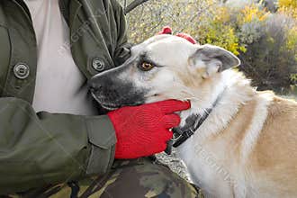 A man caresses his dog beige coloring