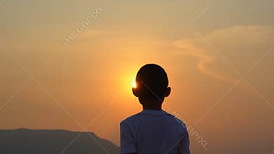 Kids boy playing exercising on morning sunrise sky background, behind Asian children relaxing on sunshine,