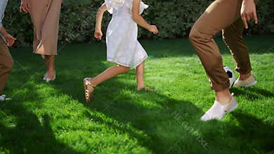 Parents and children feet playing football. Father throwing soccer ball in air