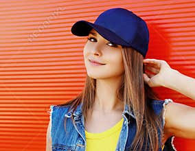 Close up summer portrait of attractive young woman wearing a blue baseball cap