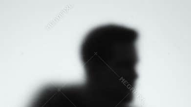 Dangerous criminal shadow looking through glass wall, maniac following victim