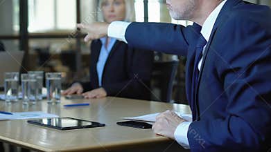 Irritated boss scolding employees, showing reports with low income, bankruptcy