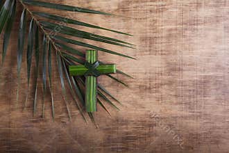 Palm sunday concept: Cross shape of palm branch on an antique wooden background