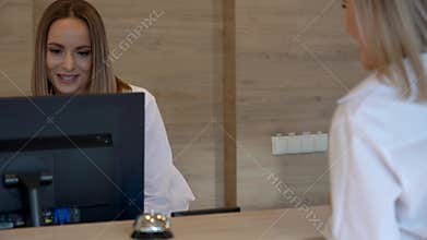 Receptionist assisting hotel guest at desk