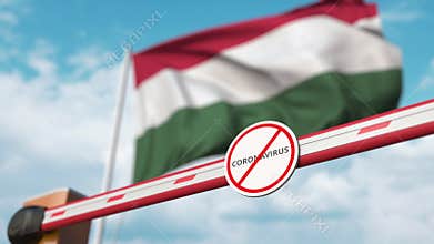 Closed boom gate with STOP CORONAVIRUS sign on the Hungarian flag background. Quarantine in Hungary