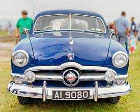 Front view on blue Ford Custom Deluxe Fordor Sedan from 1950s