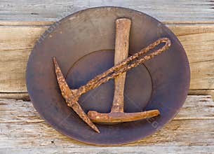 Gold pan holding two old mining picks