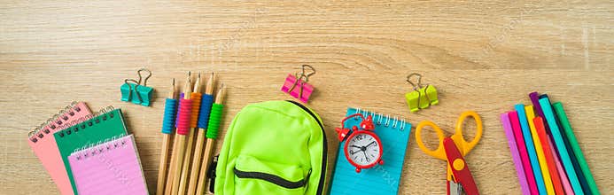 Back to school banner with school supplies on wooden desk background. Top view, flat lay