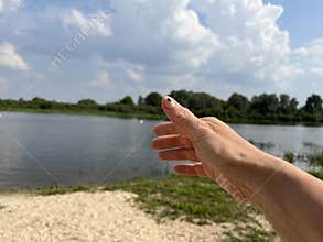 a green little beetle crawls on a woman's palm