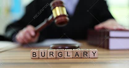 Judge bangs gavel on table with word Burglary of cubes