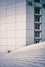 Couple sitting on staircase of the Grand Arche in La Defense in Paris