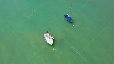 Small sailing yachts are anchored in the middle of the sea. Holidays at sea.