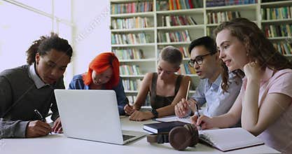 Group of multiethnic students make assignment e-learning in library
