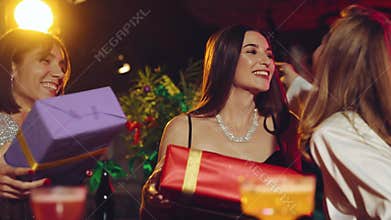 Happy young women, friends meeting in bar, restaurant, giving presents, celebrating holidays and birthday. Christmas