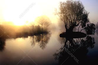 Dramatic misty lake at sunrise