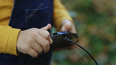 Portable control station of construction crane toy. Kid boy builder worker using remote control panel for lifting heavy