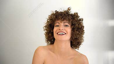 Happy girl playing with her hands in her curly afro hair