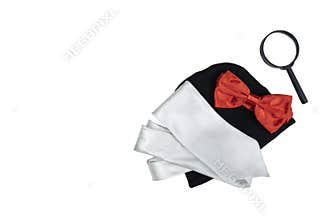 Black hat, magnifying glass, and red bow tie with silver tie