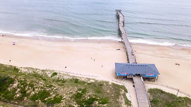 An aerial view of a fishing pier and the ocean in the town of Avon, North Carolina