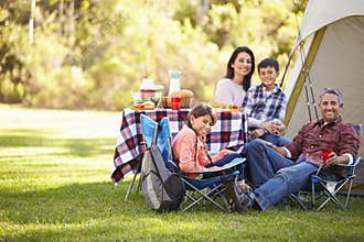 Family Enjoying Camping Holiday In Countryside