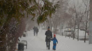 Snow blankets city streets as families stroll through winter wonderland