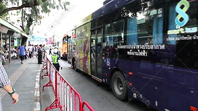 People board air-conditioned buses at the Victory Monument in Bangkok, Thailand