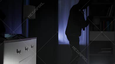 robbery, man in black clothes and a balaclava sneaks into an apartment looking for valuables at night