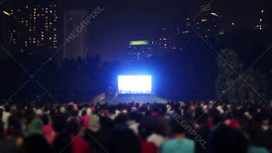 Crowded people watching tv outside in city
