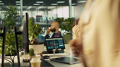 Accountant in busy modern startup agency imputing financial figures on PC