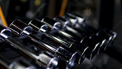 streams through large windows, lighting rows of kettlebells and dumbbells. Gym equipment neatly arranged, creating