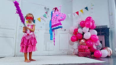 Birthday fun as a blindfolded girl hits colorful unicorn pinata