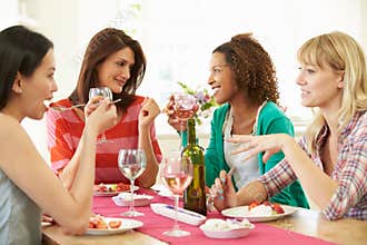 Group Of Women Sitting Around Table Eating Dessert