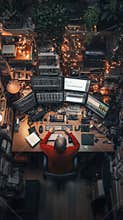 Exploring digital realms at a cozy workstation adorned with vibrant lights and books in a creative workspace. Generative