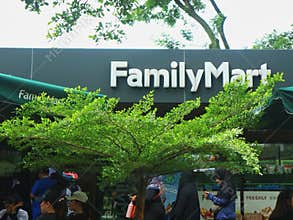 FamilyMart convenience store exterior signage framed by green trees