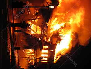 Firefighter fighting burning house.