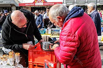 Men bargaining over goods at a flea market