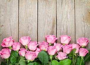 Valentines day background with pink roses over wooden table