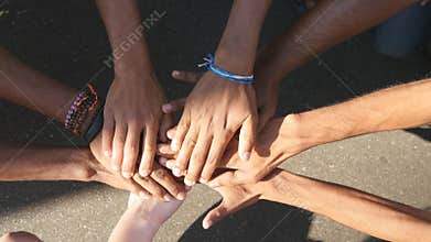 Arm of all races and colors stacked together one by one in unity and teamwork and then raised. Many multiracial hands