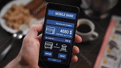 Counter payment via mobile banking application on the smartphone. A man transfers money from his credit card to another