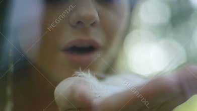 Beautiful cute lady blows feather