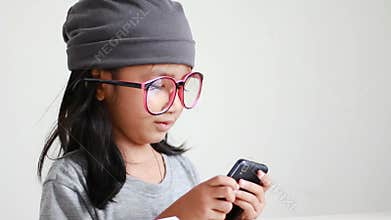 Close up shot asian little girl using mobile smartphone and showing thumbs up