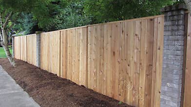 Privacy cedar fence with brick accents showing horizontal