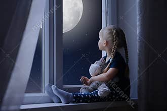Little girl looking at the starry sky and moon