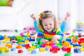 Cute little girl playing with toy blocks