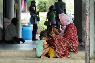 Motherhood - A poor Indian mother takes care of her children on street