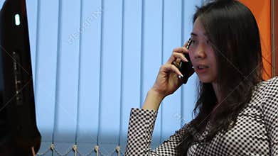 Asian Woman Talking on the phone in the office
