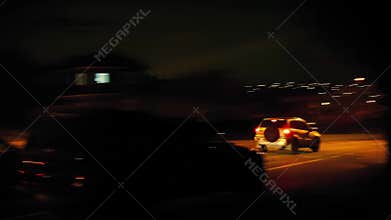 Cars Drive Past Houses In City At Night