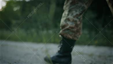 Certain military man walk on the sandy road