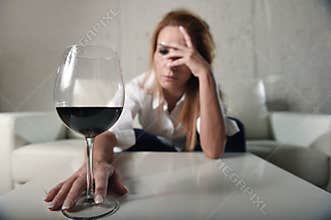 Sad depressed alcoholic drunk woman drinking at home in housewife alcohol abuse and alcoholism
