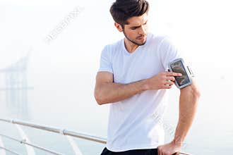 Sportsman using blank screen mobile phone on armband